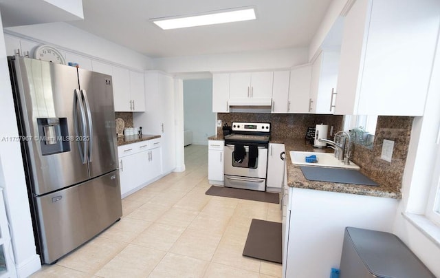 kitchen with under cabinet range hood, stainless steel appliances, a sink, white cabinets, and tasteful backsplash