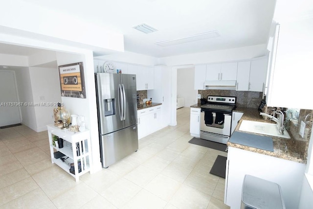 kitchen featuring under cabinet range hood, stainless steel appliances, a sink, visible vents, and tasteful backsplash