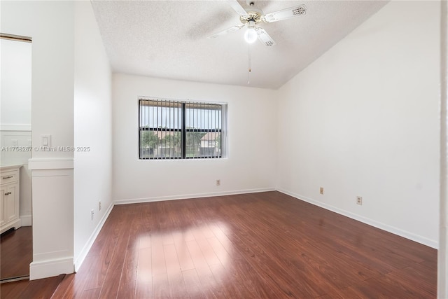 empty room with dark wood-style floors, a textured ceiling, baseboards, and a ceiling fan