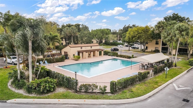 community pool featuring fence and a patio