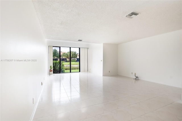 spare room featuring a textured ceiling and visible vents