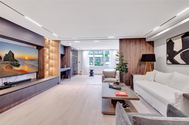 living area featuring light wood-style floors and wood walls