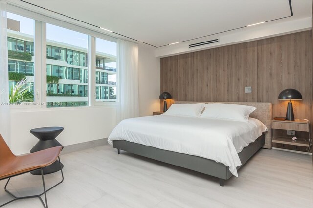 2301 Collins Ave Unit 432, Miami Beach, FL 33139 - bedroom with wood walls, light wood-style floors, and baseboards