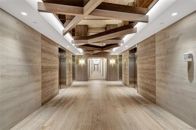 2301 Collins Ave Unit 432, Miami Beach, FL 33139 - corridor with light wood-type flooring, elevator, and beamed ceiling