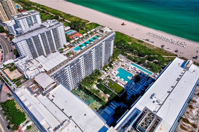 birds eye view of property featuring a water view, a view of city, and a beach view