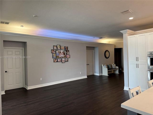 interior space featuring dark wood-style floors, ornamental molding, visible vents, and baseboards