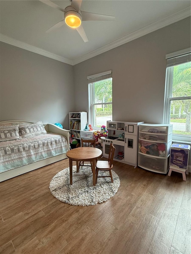 bedroom with crown molding, ceiling fan, and wood finished floors