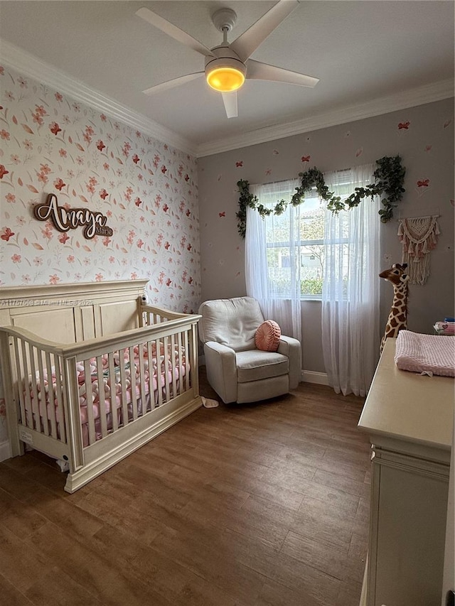 bedroom with wallpapered walls, crown molding, and a nursery area