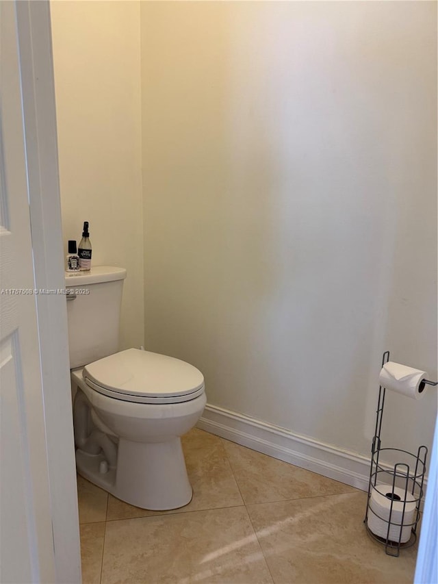 bathroom featuring baseboards, toilet, and tile patterned floors