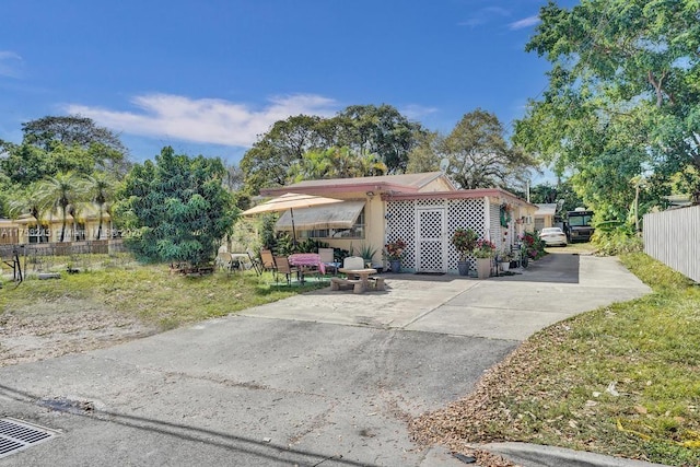 view of front of property with a patio area and fence