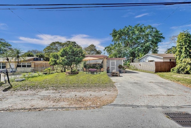 view of front of property featuring fence, a fire pit, and a patio