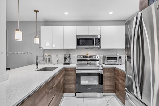 kitchen with a toaster, stainless steel appliances, a sink, white cabinets, and backsplash