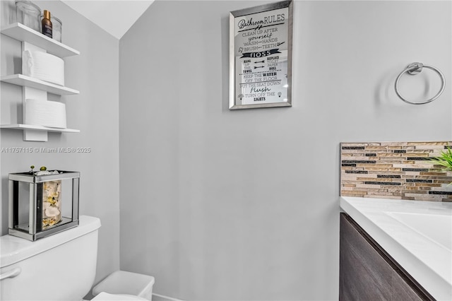 half bathroom featuring tasteful backsplash and toilet