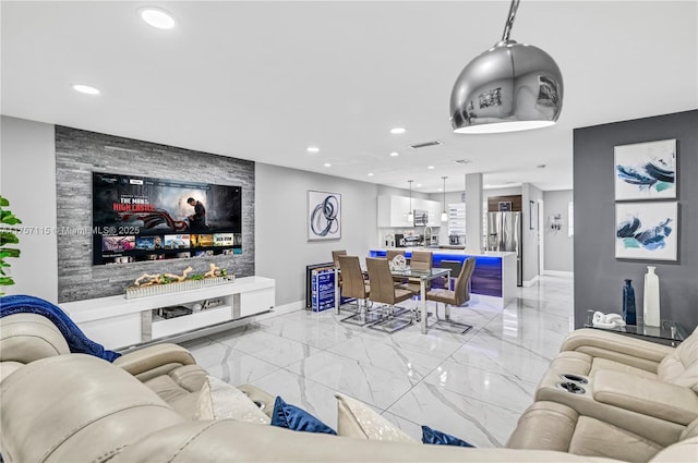 living area with recessed lighting, marble finish floor, and baseboards