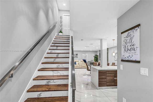 staircase featuring baseboards, marble finish floor, and recessed lighting