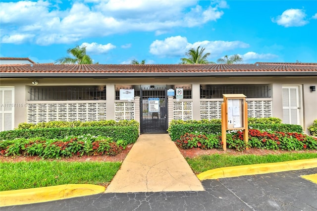 entrance to property featuring a tiled roof and stucco siding