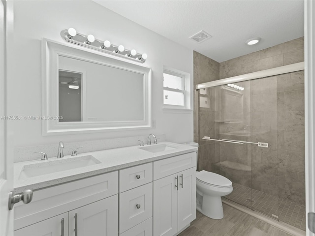 bathroom featuring a shower stall, visible vents, and a sink