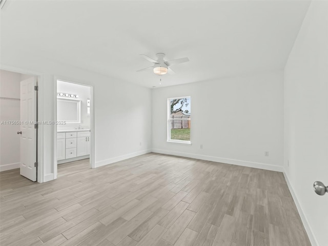 unfurnished bedroom with baseboards, a ceiling fan, light wood-style flooring, a walk in closet, and a closet