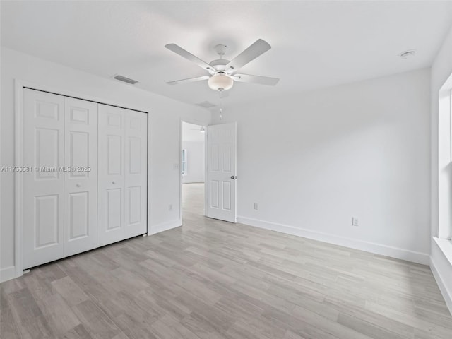 unfurnished bedroom featuring light wood finished floors, a closet, visible vents, ceiling fan, and baseboards