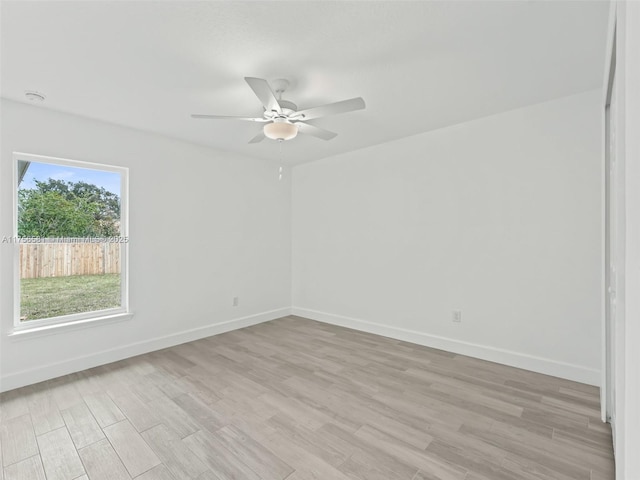 empty room featuring light wood-style flooring, baseboards, and ceiling fan