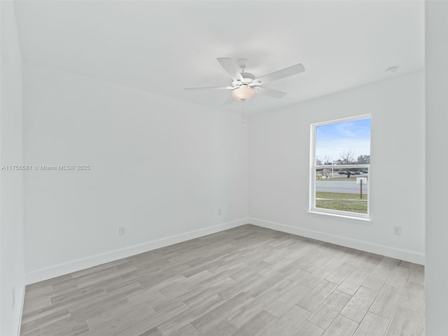 empty room featuring ceiling fan, light wood-type flooring, and baseboards