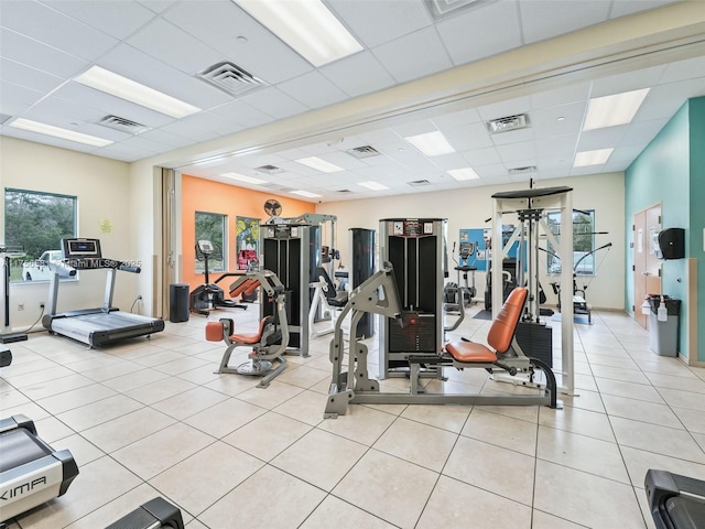 exercise room featuring visible vents, a drop ceiling, and light tile patterned flooring