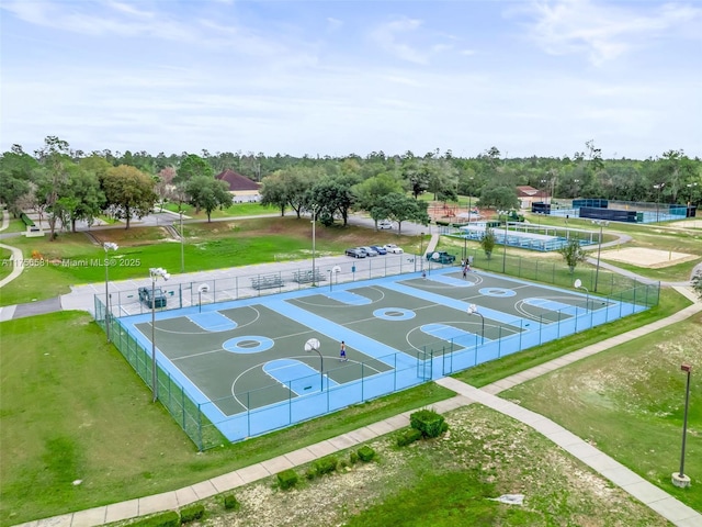 exterior space with community basketball court, a lawn, and fence