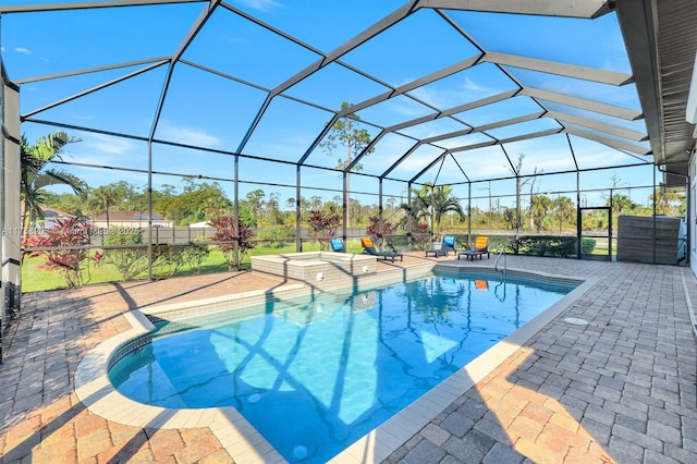 outdoor pool featuring glass enclosure, a patio, and a jacuzzi