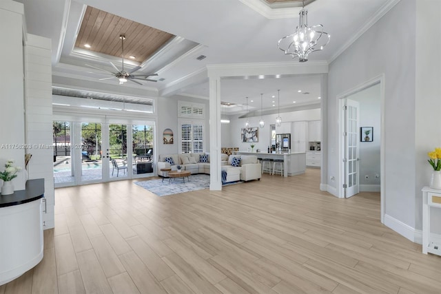 living area featuring visible vents, a tray ceiling, crown molding, french doors, and light wood-style floors