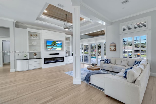 living area featuring ornamental molding, plenty of natural light, a glass covered fireplace, and visible vents