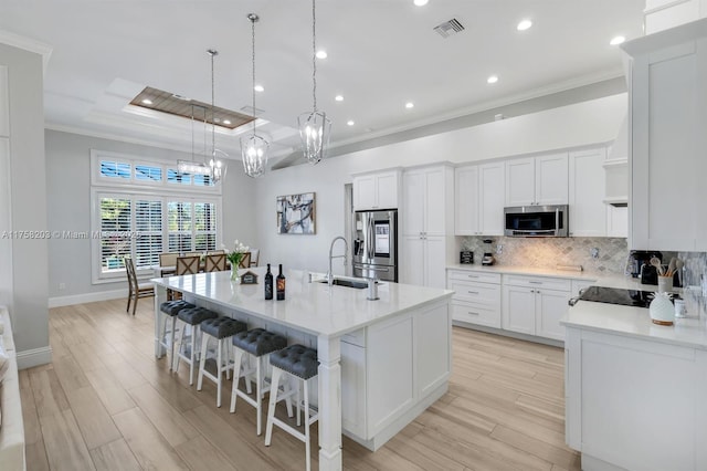 kitchen featuring stainless steel appliances, visible vents, a sink, and decorative backsplash