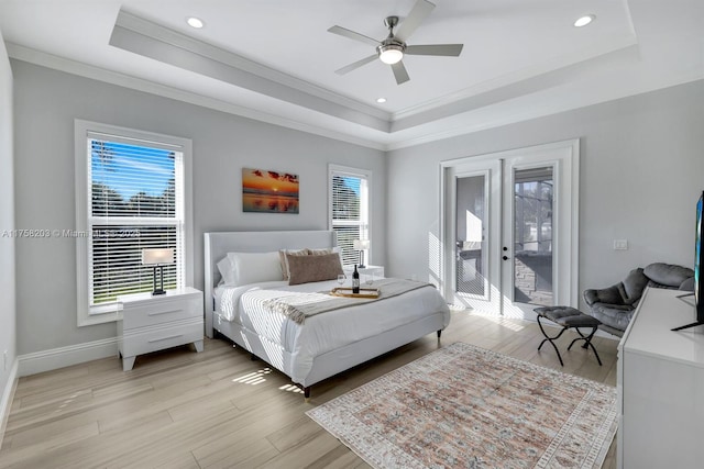 bedroom with access to outside, a raised ceiling, crown molding, and light wood-style flooring