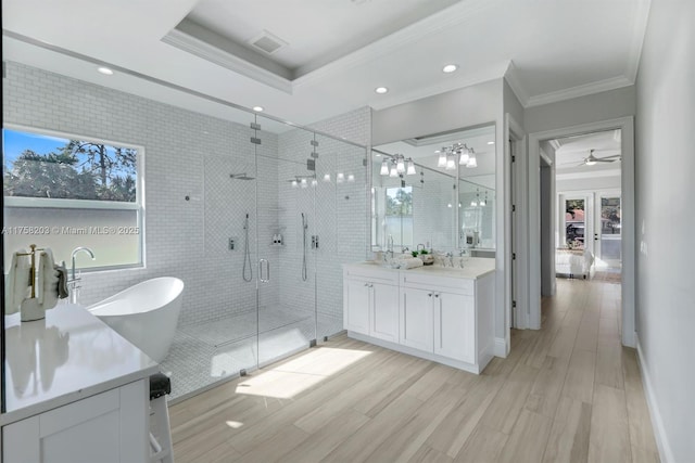 full bathroom with crown molding, visible vents, a stall shower, vanity, and wood finished floors