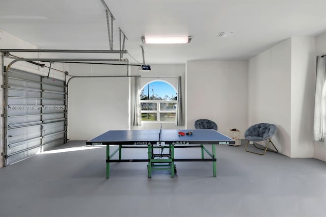 recreation room with a garage and finished concrete floors