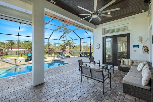 view of patio / terrace featuring an outdoor hangout area, a ceiling fan, glass enclosure, an in ground hot tub, and an outdoor pool