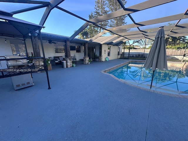 view of swimming pool featuring a lanai, a patio area, and fence