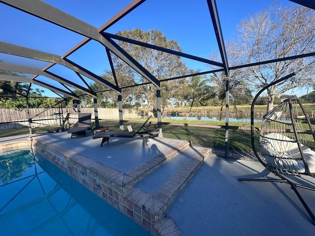 view of pool featuring a lanai, a patio area, fence, and a water view