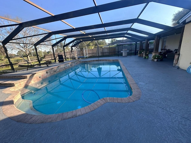 view of swimming pool with a fenced in pool, glass enclosure, a patio area, and a fenced backyard