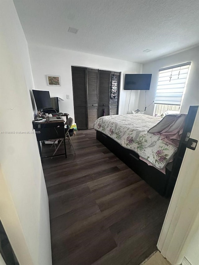 bedroom featuring dark wood-style floors and a textured ceiling