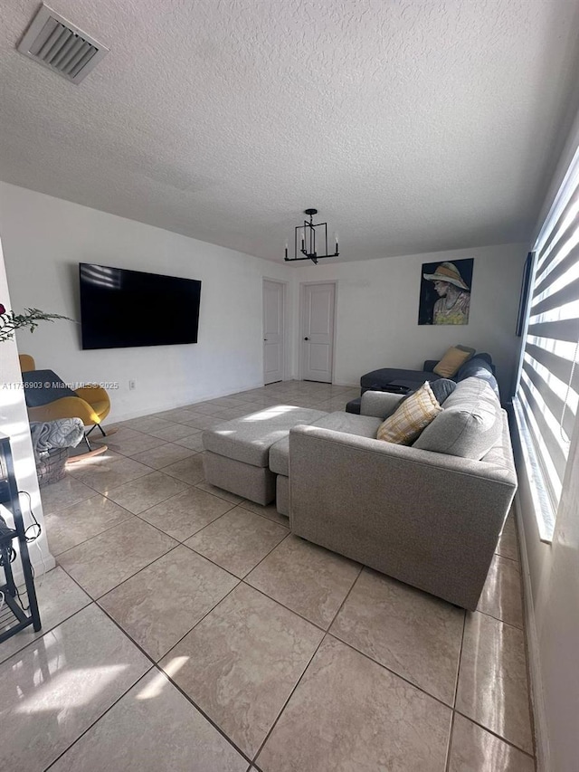 tiled living room with visible vents and a textured ceiling