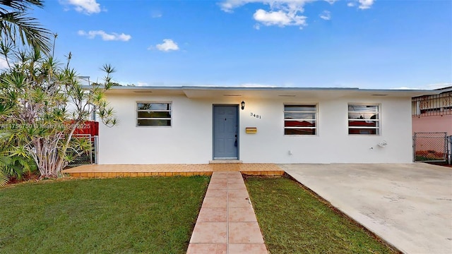 view of front of house with a patio, a front yard, fence, and stucco siding