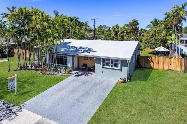 view of front of home featuring a front yard, fence, driveway, and stucco siding