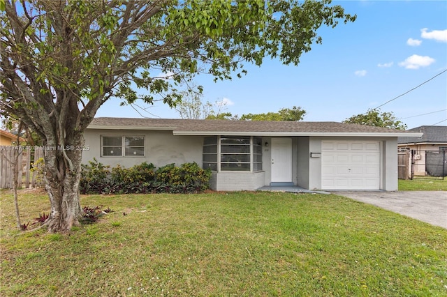 ranch-style house featuring a front yard, fence, concrete driveway, and stucco siding