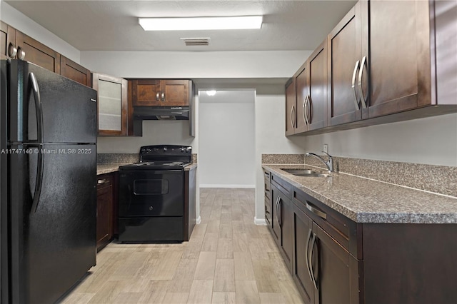 kitchen with dark brown cabinetry, visible vents, under cabinet range hood, black appliances, and a sink