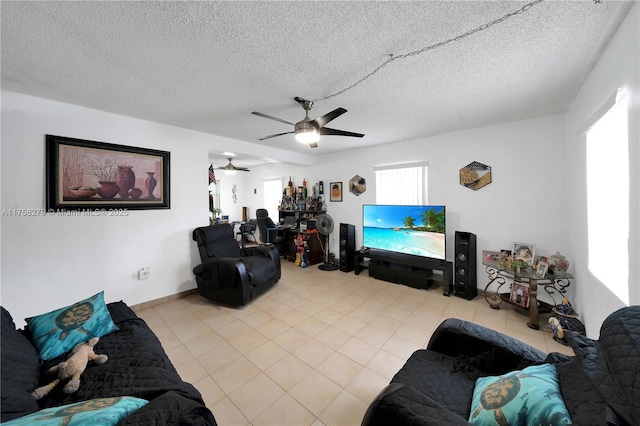 living area featuring light tile patterned floors, ceiling fan, and a textured ceiling