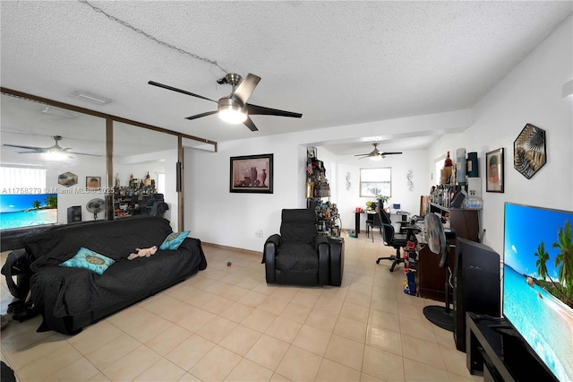 living area featuring a textured ceiling, visible vents, and a ceiling fan