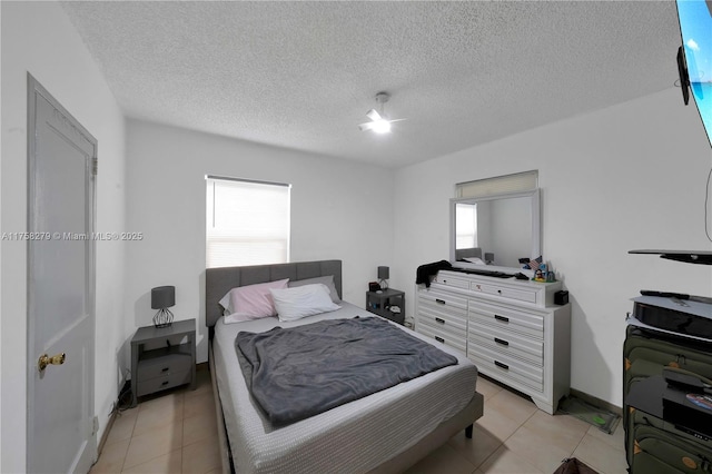 bedroom with light tile patterned floors and a textured ceiling