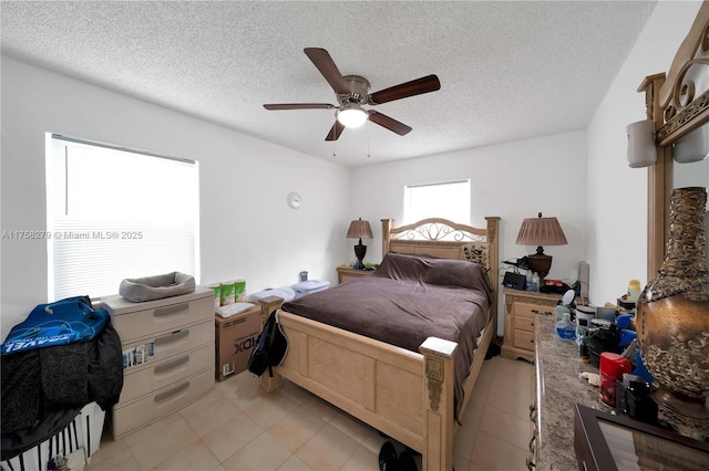 bedroom with ceiling fan, a textured ceiling, and light tile patterned flooring