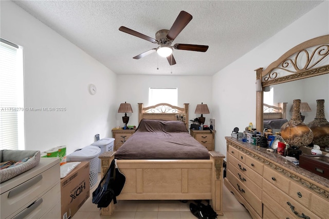 bedroom with light tile patterned floors, a ceiling fan, and a textured ceiling