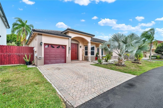 view of front of house with a front lawn, fence, an attached garage, and stucco siding